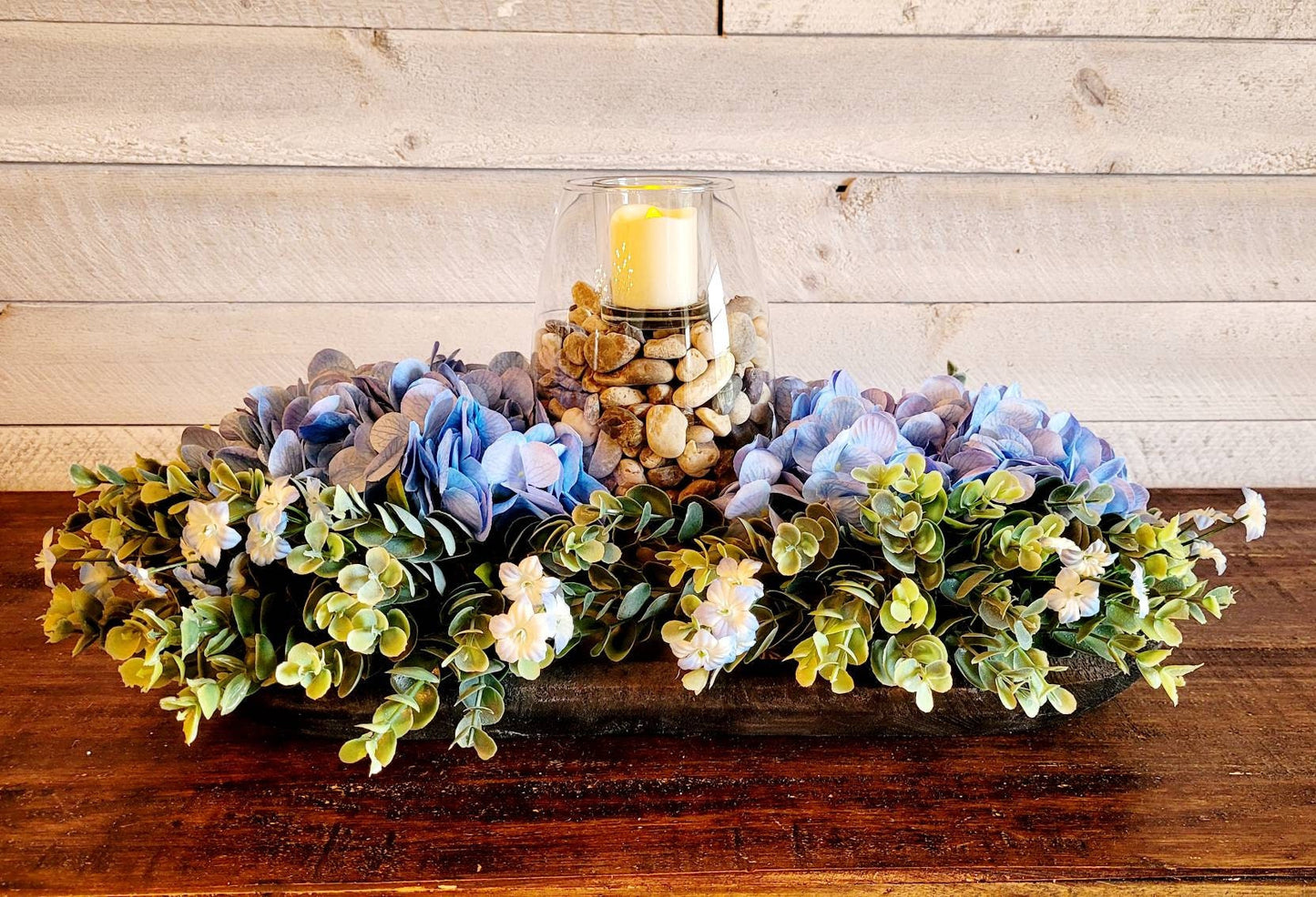 Farmhouse Dining Decor Rustic Table Centerpiece Black Dough Bowl Arrangement Blue Hydrangea Design Modern Country Style Natural Rock Elements Glass Vase Feature Votive Candle Accent Nineteen Inch Bowl Traditional Home Styling Mantle Display