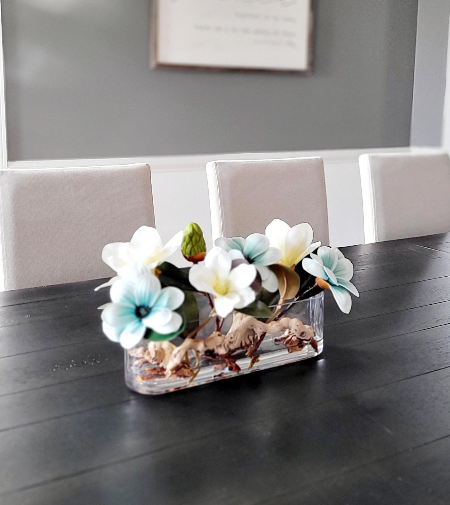 Faux Magnolia Centerpiece Blue Flower Arrangement Glass Vase Display Artificial Floral Design Dining Table Decoration Elegant Home Accent Realistic Bloom Collection Permanent Flower Display Modern Interior Style Contemporary Dining Room