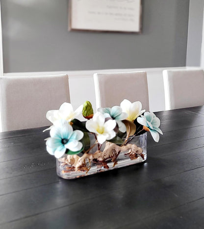 Faux Magnolia Centerpiece Blue Flower Arrangement Glass Vase Display Artificial Floral Design Dining Table Decoration Elegant Home Accent Realistic Bloom Collection Permanent Flower Display Modern Interior Style Contemporary Dining Room