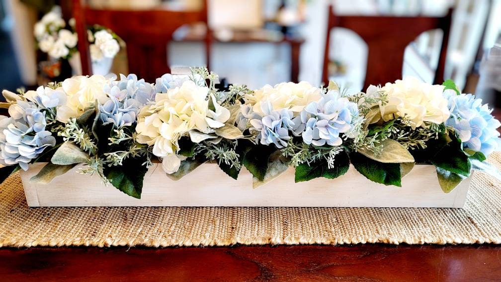 Rustic Wood Box Centerpiece Blue Hydrangea Arrangement Long Farmhouse Mantel Display Custom Wooden Box White Wash Finish Cream And Light Blue Flowers Lambs Ear Greenery Texture Perfect Dining Table Styling Elegant Country Home Accent