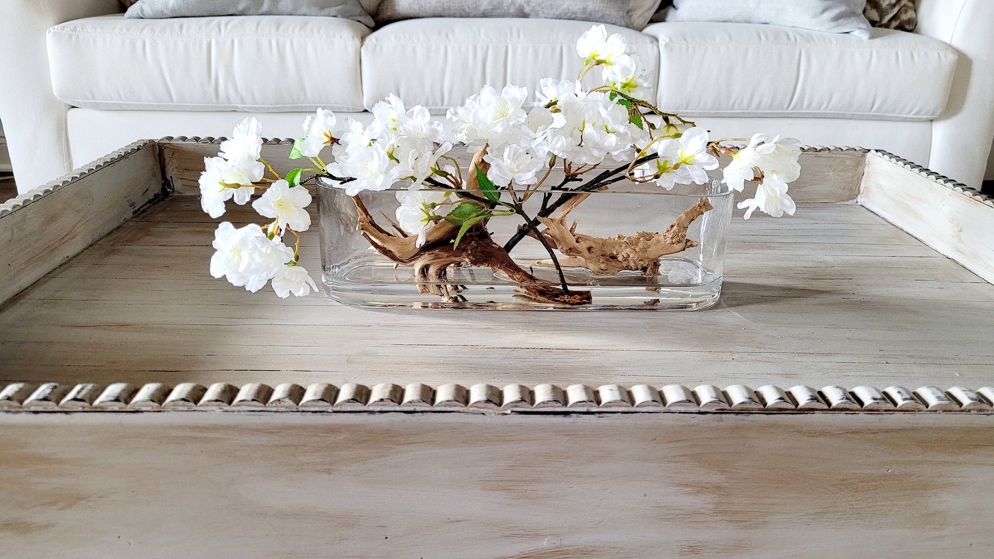Dining Table Centerpiece Modern Design White Orchid Arrangement Natural Driftwood Accent Glass Oval Vase Silk Floral Display Contemporary Home Decor Handcrafted Artistic Creation Elegant Table Setting Maintenance Free Beauty Statement Piece