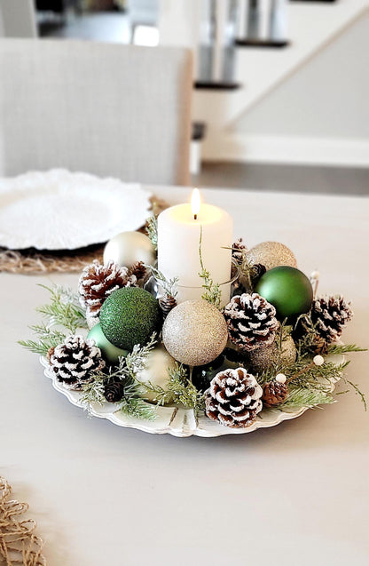 Christmas Candle Centerpiece Farmhouse Style Holiday Table Styling Rustic Pinecone Arrangement Natural Evergreen Sprigs Gold Ornament Display Red Ball Styling Festive Dining Table Setting Winter Season Home Styling White Pillar Candle