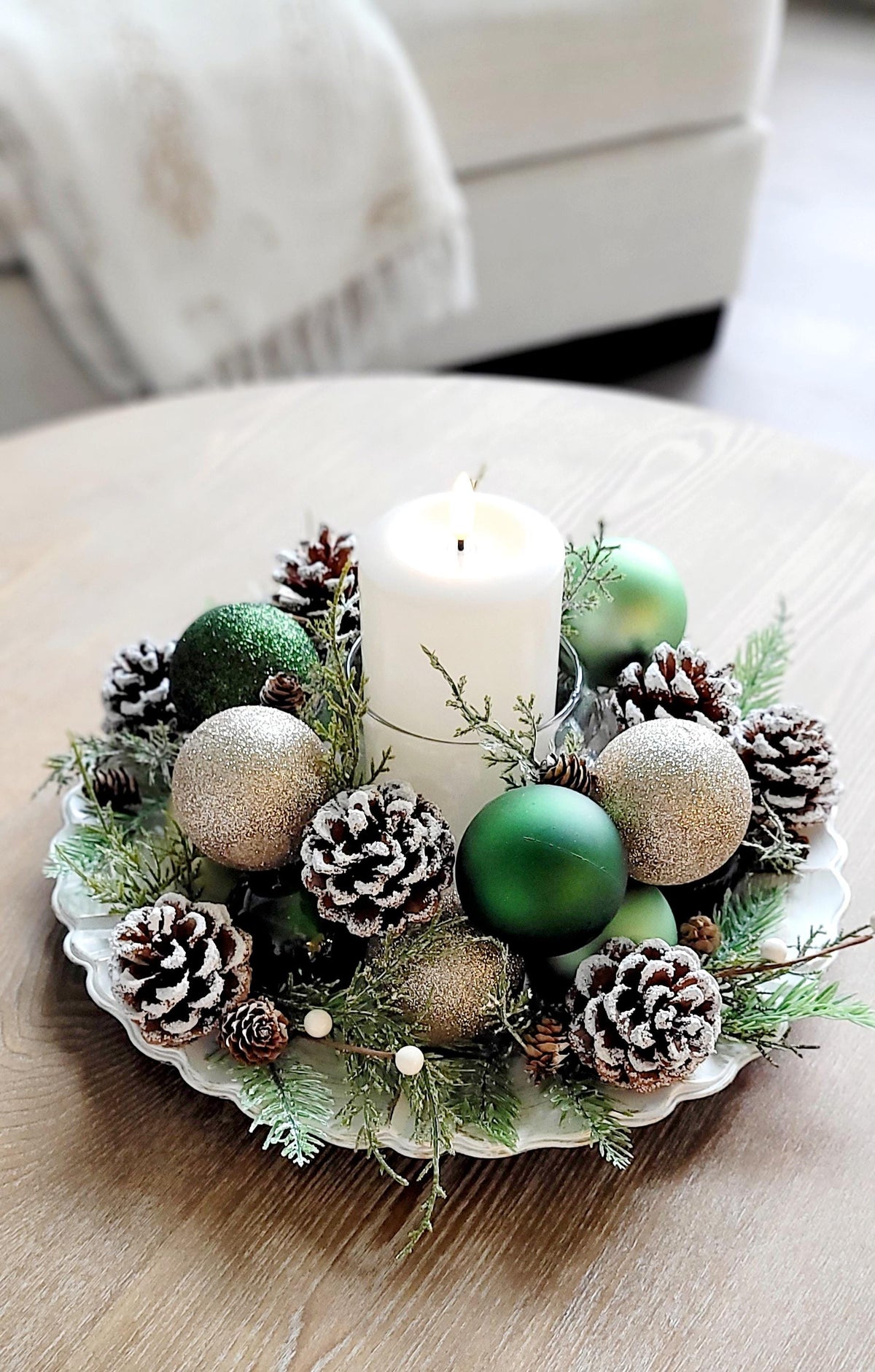 Rustic Christmas Table Centerpiece Handmade Holiday Styling Farmhouse Pinecone Arrangement White Candle Holder Display Natural Evergreen Sprigs Gold Red Ornament Styling Festive Dining Room Setting Winter Season Home Styling Traditional