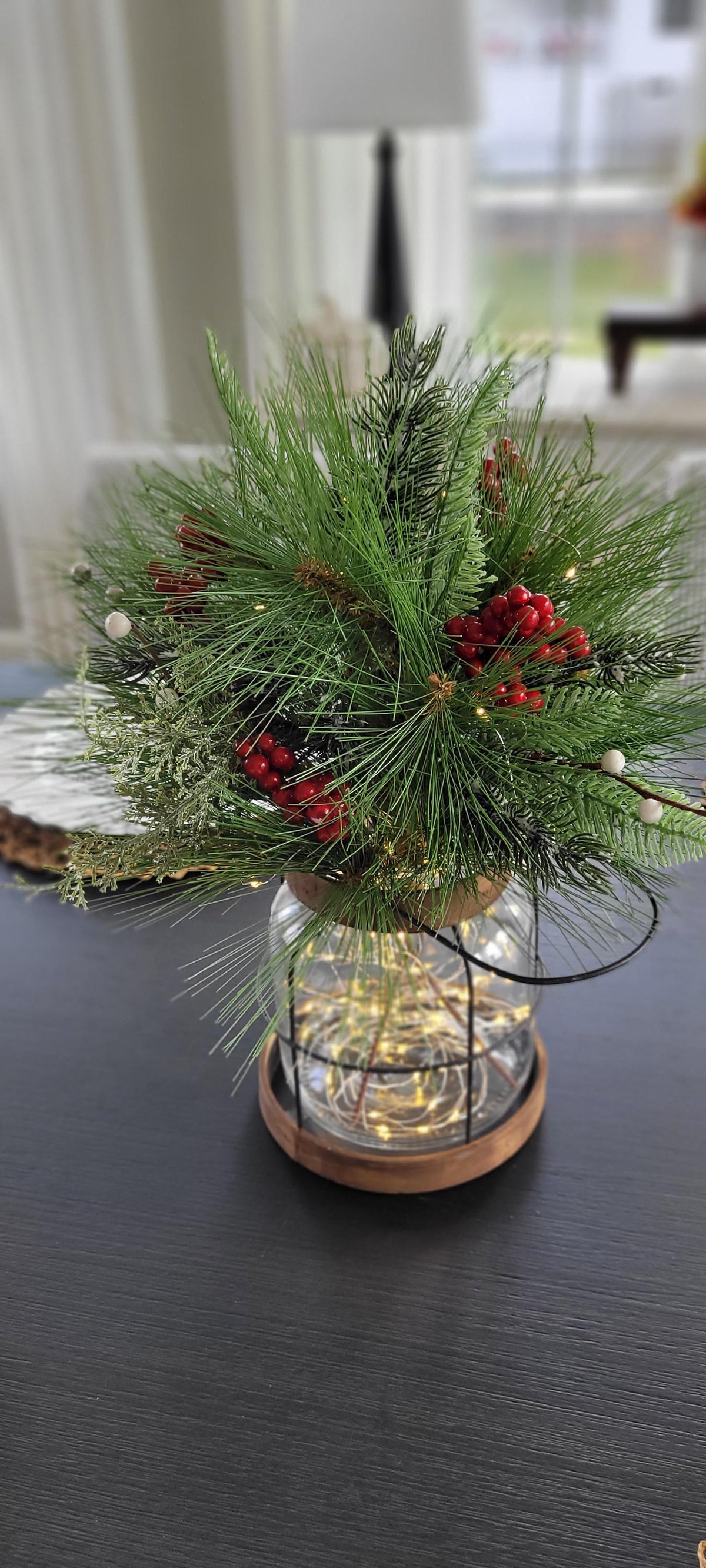 Winter Pine Centerpiece Farmhouse Christmas Lantern Rustic Holiday Table Styling Lighted Berry Arrangement Warm Glowing String Lights Indoor Seasonal Display Cozy Country Home Styling Festive Dining Room Mantel Console Natural Greenery Red