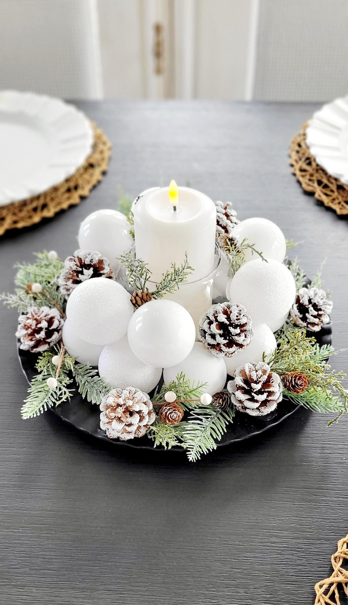 Farmhouse Christmas Table Centerpiece White Pillar Candle Display Frosted Winter Styling Snow Dusted Pine Cones Natural Evergreen Sprigs White Berry Accents Elegant Holiday Dining Setting Rustic Winter Wedding Styling Scandinavian Christmas