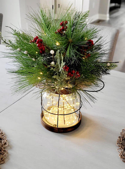 Christmas Table Centerpiece Farmhouse Lantern Design Rustic Winter Pine Berry Arrangement Warm Lighted Display Indoor Holiday Styling Cozy Festive Ambiance Country Home Dining Room Mantel Console Styling Natural Greenery Red Berry Accents