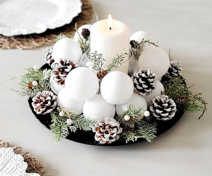 White Christmas Centerpiece Candle Holder Arrangement Farmhouse Winter Styling Frosted Pine Cone Display Natural Evergreen Accents Snowy White Ornament Balls Elegant Holiday Table Setting Rustic Seasonal Styling Winter Wedding Centerpiece